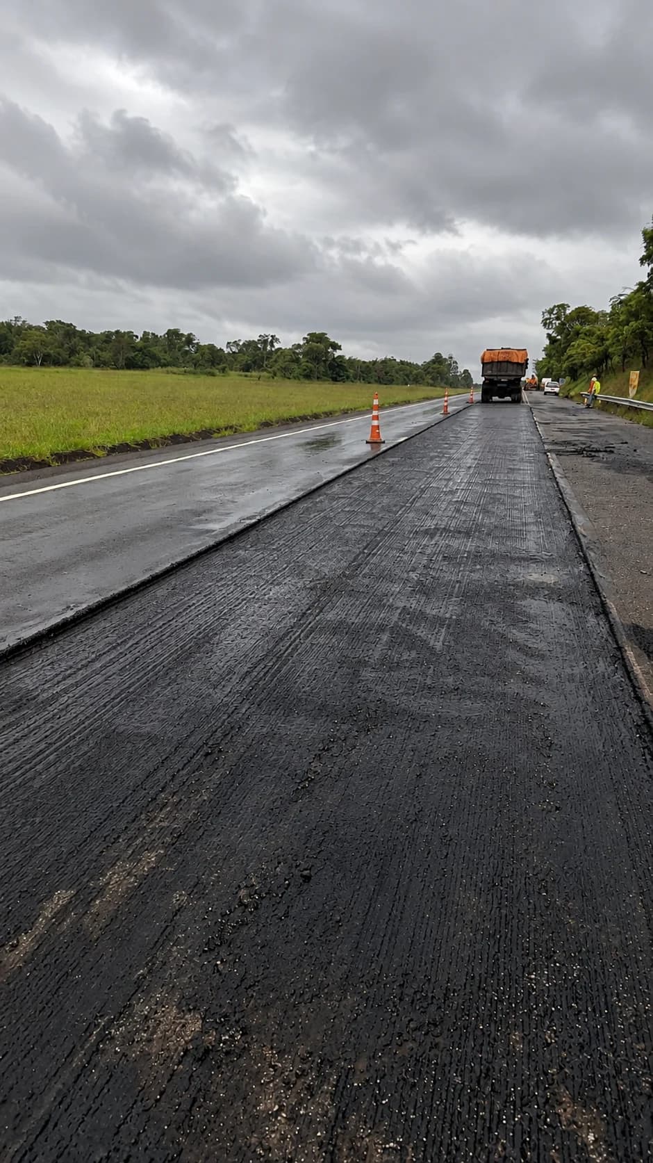 Nuvens escuras sobre a pista e um caminhão em uma frente de trabalho